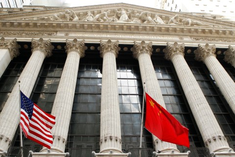 The flags of the United States and China hang outside of the New York Stock Exchange