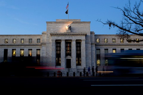 Image: Vehicles pass the U.S. Federal Reserve building in Washington, D.C. 