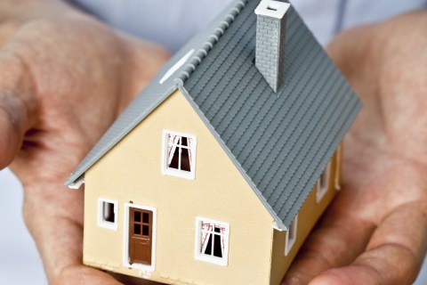 Man holding small model house.