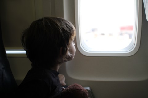 Child sitting by window in airplane