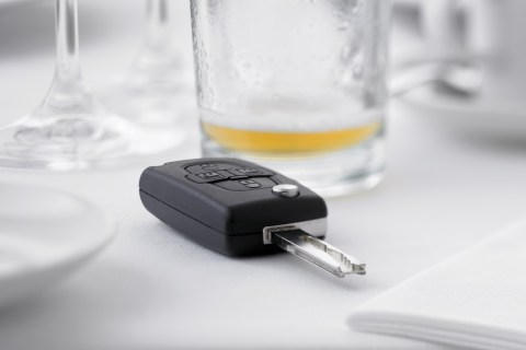 Close up of car key next to empty beer glass