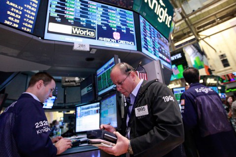 Traders work at the Knight Capital kiosk on the floor of the New York Stock Exchange