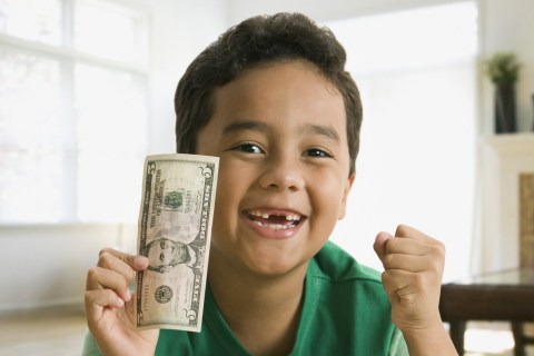 Boy holding $5 bill, missing tooth
