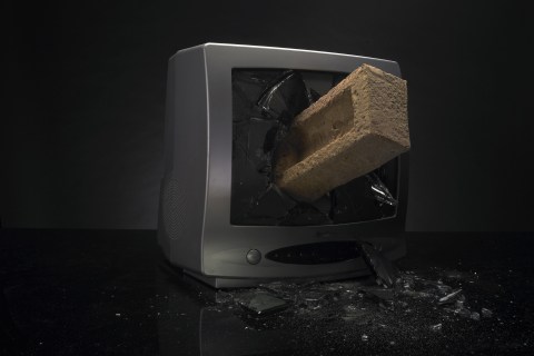 Television screen being smashed by a brick