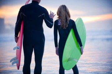 father instructing daughter before going surfing