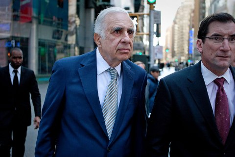 image: Carl Icahn walks outside of the Nasdaq MarketSite with Robert Greifeld, chief executive officer and president of Nasdaq OMX Group Inc., in New York, March 27, 2012. 