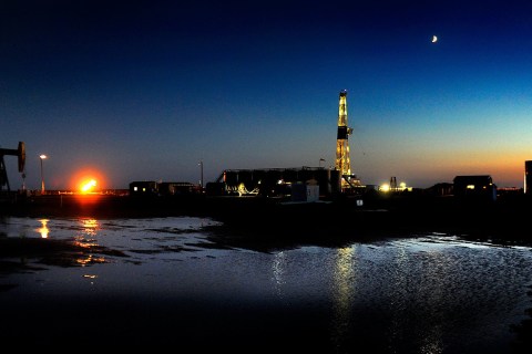 image: An oil drilling rig at dusk near New Town, North Dakota on June 29, 2012.