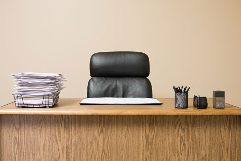 Office desk with overflowing inbox