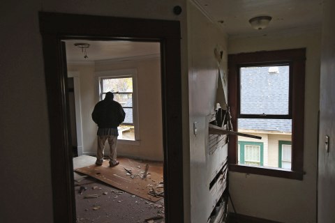 A homeless man looks from the window of a condemned house in Warren, Ohio, Oct. 28, 2012.
