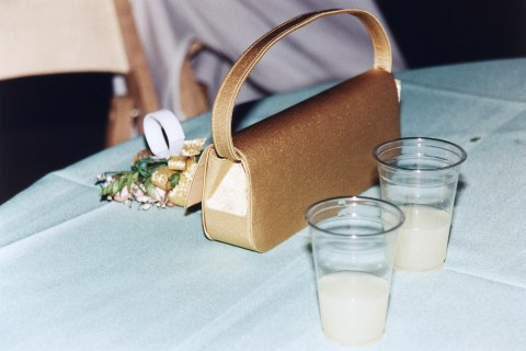 Gold bag, corsage and plastic cups on table, Prom