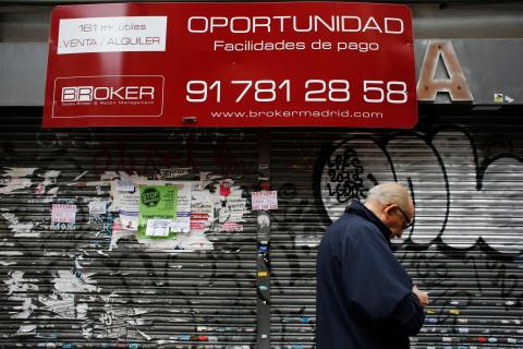 A man walks past a closed down business in Madrid