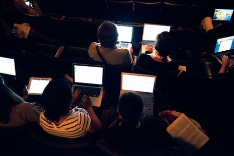 Aerial View Of People Attending A Talk While Working On Laptops