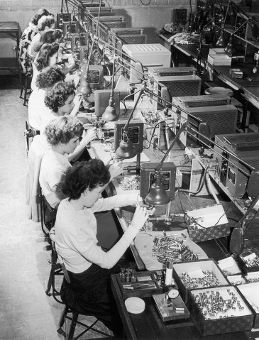 Female factory workers assembling machine parts in an American factory during World War II in 1942.