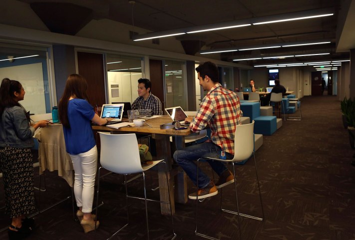 Twitter employees gather at a table at the company's headquarters in San Francisco