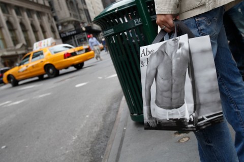 A man holds a shopping bag from  Abercrombie & Fitch outside their store in New York