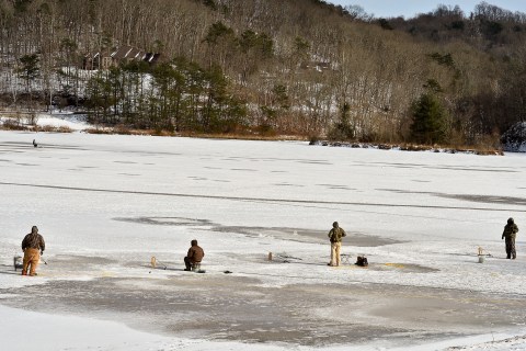 A group of ice fishers gather on the frozen surface of Ridenour Lake in Nitro, W.Va., Jan. 27, 2014.   